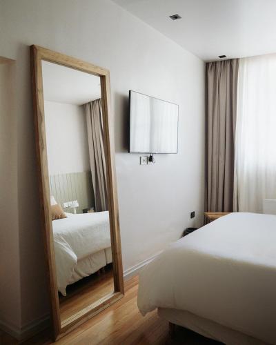 a mirror in a hotel room with two beds at Casa Toledo in La Cumbre