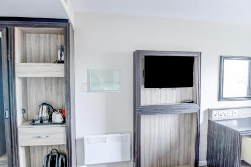 a living room with a tv in the corner of a room at Belvilla Aberdeen Bridge of Don Exhibition Centre in Aberdeen