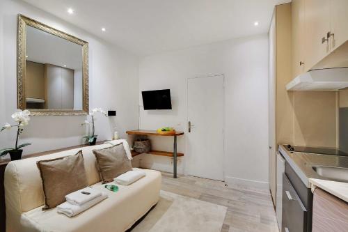 un salon avec un canapé et un miroir dans l'établissement Flexliving - studio - Montreuil, à Paris