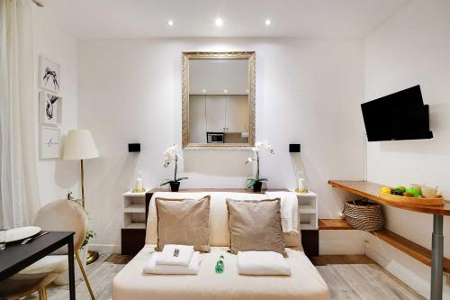 un salon avec un canapé et un miroir dans l'établissement Flexliving - studio - Montreuil, à Paris