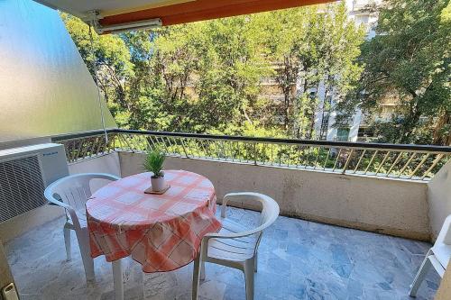 d'une table et de chaises sur un balcon avec vue sur les arbres. dans l'établissement AHC - Fleuries2 - Grand Studio terrasse, à Cannes