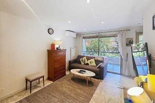 un salon avec un canapé et une table dans l'établissement AHC - Fleuries2 - Grand Studio terrasse, à Cannes