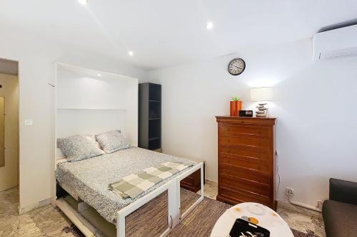 - une petite chambre avec un lit et une commode dans l'établissement AHC - Fleuries2 - Grand Studio terrasse, à Cannes