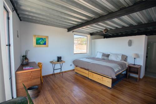 a bedroom with a bed and a wooden floor at 3 deptos en el mismo lugar: Penthouse con doble altura y magnífica arquitectura, Loft con cocina integral y Departamento en planta baja con patio. in San Miguel de Allende