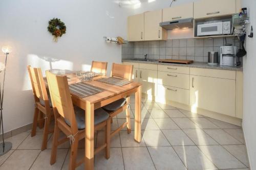 a kitchen with a wooden table and chairs at Seepark Störtebekers Nest in Scharbeutz