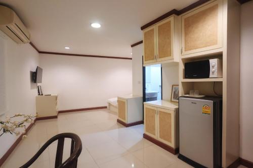 a kitchen with a refrigerator and a microwave at Sampheng House in Bangkok