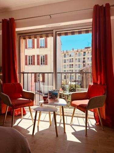 une chambre avec deux chaises, une table et une grande fenêtre dans l'établissement Riviera Sun, à Nice