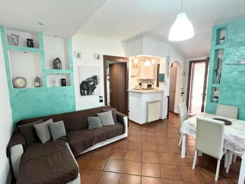 Una sala de estar con un sofá y una mesa y una cocina. en Karol Beach House, en Santa Marinella