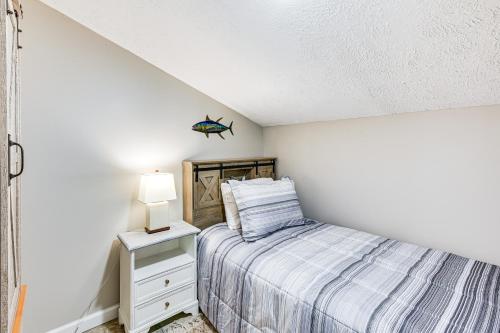 a bedroom with a bed and a lamp on a night stand at 13 Mi to St Andrews State Park Cabin with Patio! in Panama City