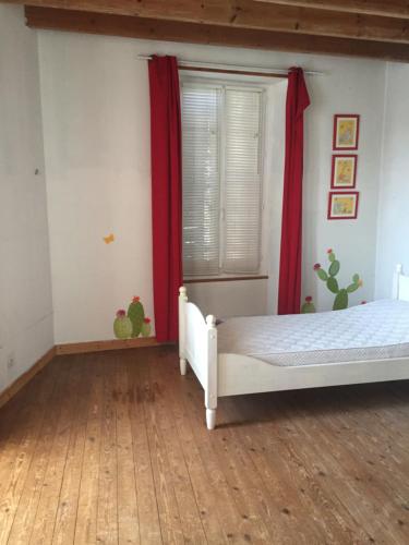 une chambre avec un lit et une fenêtre avec des rideaux rouges dans l'établissement Maison de la mare aux rainettes Location vacances standing au cœur du marais poitevin - 3 chambres - 6 personnes, à La Celle-sous-Gouzon