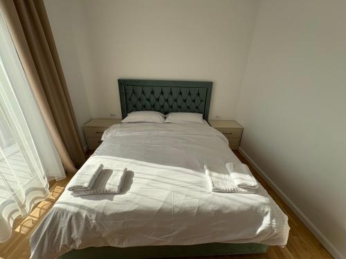 a bedroom with a bed with two towels on it at Travelers Home Downtown in Ipoteşti
