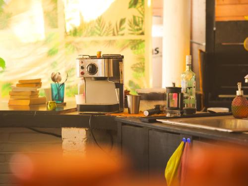 a kitchen counter with a sink and a toaster oven at Wajakita Experience Hostel in Zipolite