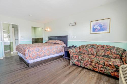 a hotel room with a bed and a couch at Day & Night Inn in Hesperia