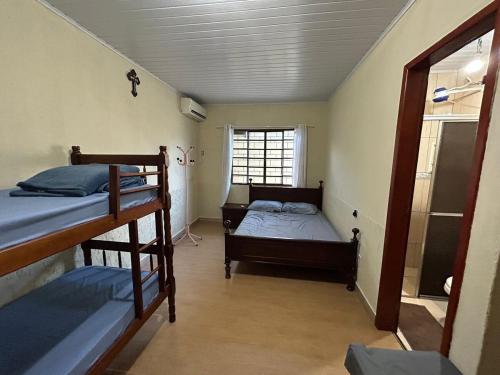 a room with two bunk beds and a window at Casa ampla com 02 suítes e 01 quarto próx das Cataratas e Aeroporto in Foz do Iguaçu
