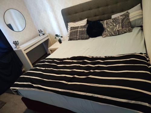 a bed with a black and white striped blanket and pillows at The castle & stay in Örebro