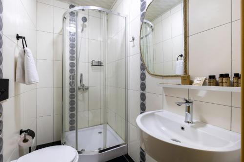 a bathroom with a shower and a sink and a toilet at Acord Hotel & Balcony in Batumi