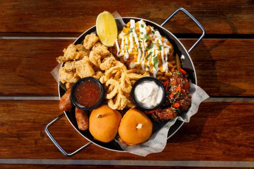 a plate of food with onion rings and dips at Le Royal Meridien Abu Dhabi in Abu Dhabi