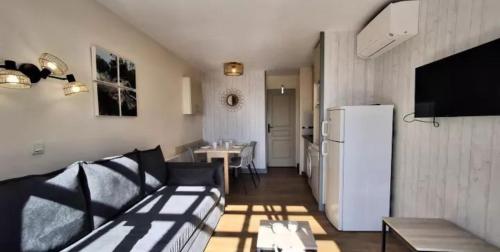- un salon avec un canapé et un réfrigérateur dans l'établissement Appartement 2 chambres Cap Estérel vue mer, à Agay