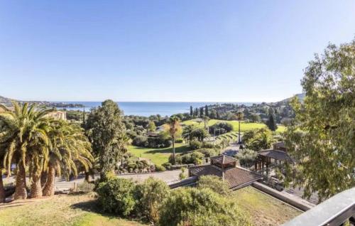 - une vue aérienne sur un parc planté de palmiers et l'océan dans l'établissement Appartement 2 chambres Cap Estérel vue mer, à Agay