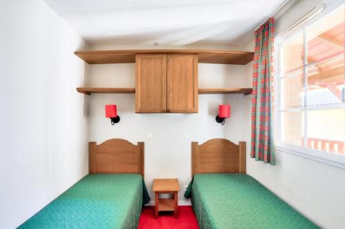 deux lits jumeaux dans une chambre avec fenêtre dans l'établissement La résidence du Lac - maeva Home - Appartement 2 Pièces 4 Personnes - Sélection MAE-3714, à Monflanquin