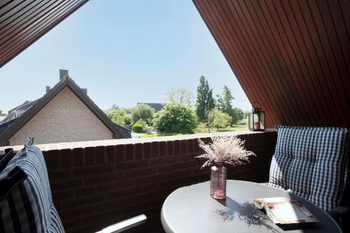 a vase of flowers on a table on a balcony at Hasenkamp 18 Krabbe in Grömitz