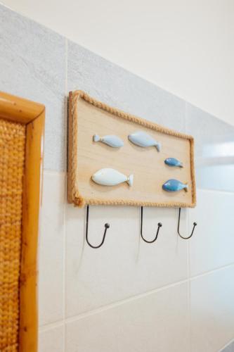 a wooden shelf on a wall with fish hooks at Dimora Vittoria Apartment in Montesilvano