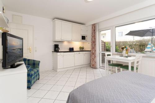 a kitchen and dining room with a table and a television at Seepferdchen Urlaubstied in Hansaland