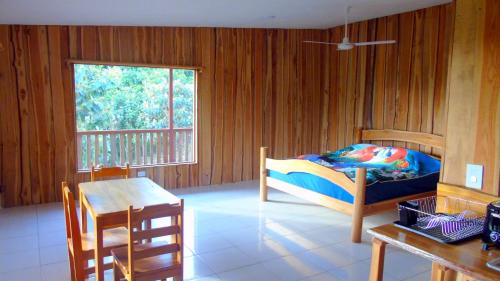 une chambre avec un lit, une table et une fenêtre dans l'établissement Corcovado Tropical Garden Lodge, à Drake