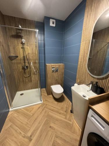 a bathroom with a shower and a toilet and a sink at Travel Apartament Płock in Płock