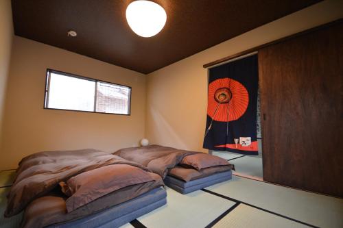1 dormitorio con 2 camas y ventana en Serendipity at Kyoto, en Kioto