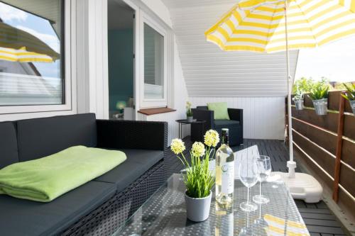 une terrasse avec un canapé, une table et un parasol dans l'établissement Ferienhaus Freitag, à Kellenhusen