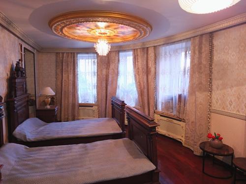 a bedroom with two beds and a chandelier at Baltā māja in Rīga