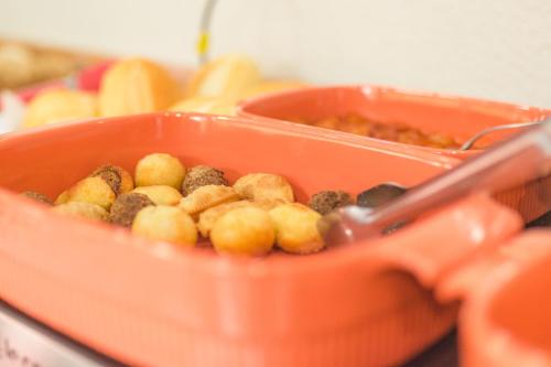 an orange container filled with food on a table at Lukinhas Pousada in Nobres