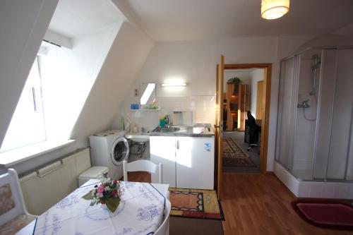 eine kleine Küche mit einem Tisch und einem Waschbecken in der Unterkunft Karin's behagliche Ferienwohnung in Benshausen
