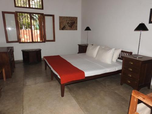 a bedroom with a bed with white sheets and pillows at Mannankulam Villa in Akkaraipattu