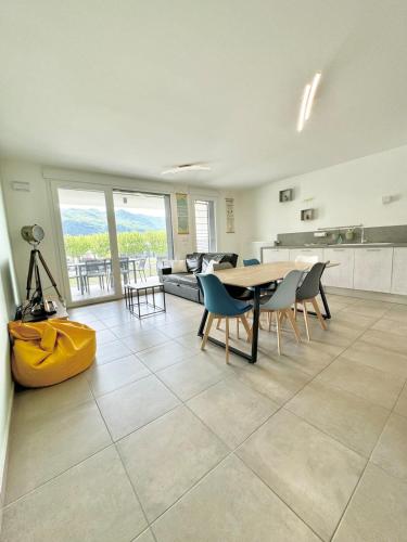 un grand salon avec une table et des chaises dans l'établissement Le Dolce lake beach parking, à Aix-les-Bains