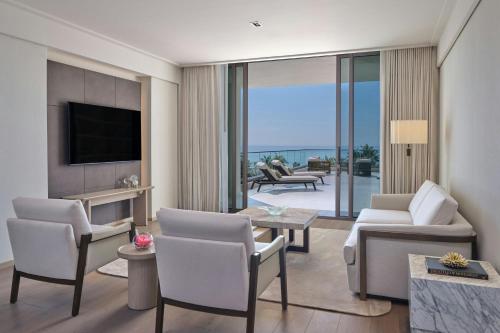 a living room with a couch and chairs and a television at The St. Regis Longboat Key Resort in Longboat Key