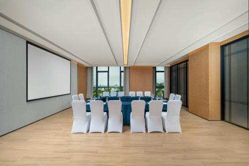 a conference room with a blue table and white chairs at Fairfield by Marriott Taishan in Jiangmen