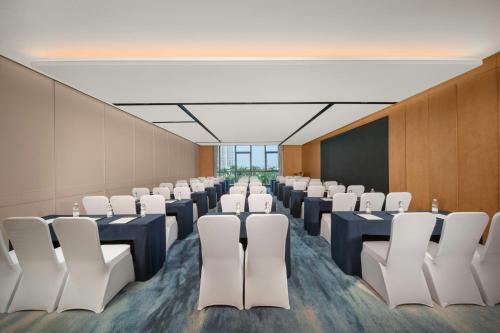 a room with rows of tables and white chairs at Fairfield by Marriott Taishan in Jiangmen