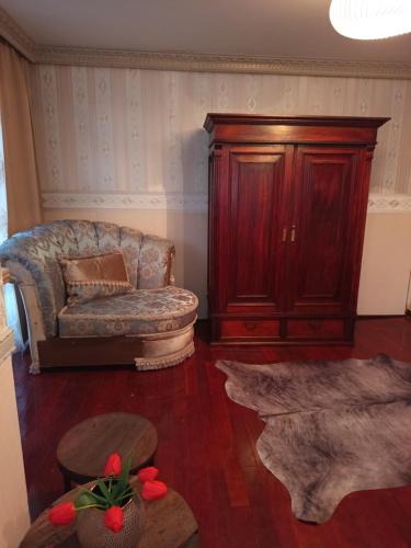 a living room with a couch and a wooden cabinet at Baltā māja in Rīga