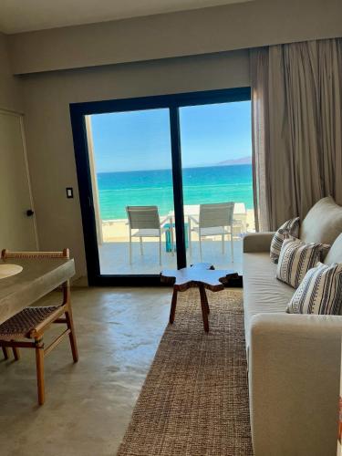 a living room with a couch and a view of the ocean at Dpto frente a la playa Beach Front Bahia turquesa in La Ventana