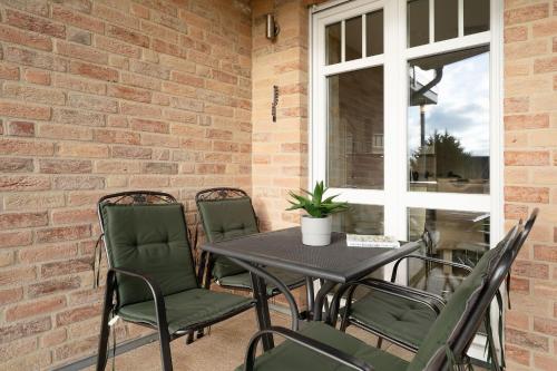 un patio avec une table, des chaises et une fenêtre dans l'établissement Bürgermeister-Fox 42a Meer-Blick, à Neue Tiefe Fehmarn