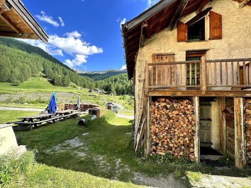 a building with a bunch of logs next to it at Chalet d'alpage au coeur du Parc naturel du Queyras - exceptionnel in Valpreveyre