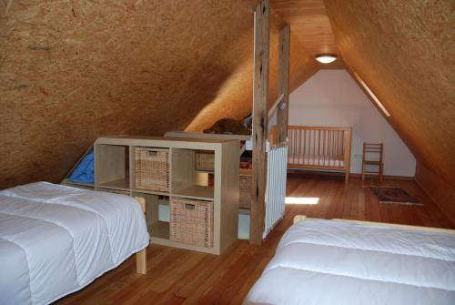 een slaapkamer op zolder met 2 bedden en een trap bij Holiday Home Garnaalhuisje in Oostduinkerke