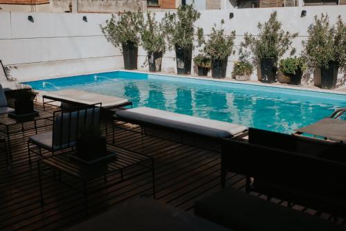 a swimming pool with tables and chairs and plants at Premium Tower Suites Mendoza in Mendoza