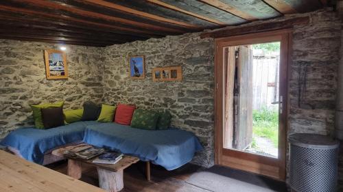 a living room with a couch and a window at Chalet d'alpage au coeur du Parc naturel du Queyras - exceptionnel in Valpreveyre