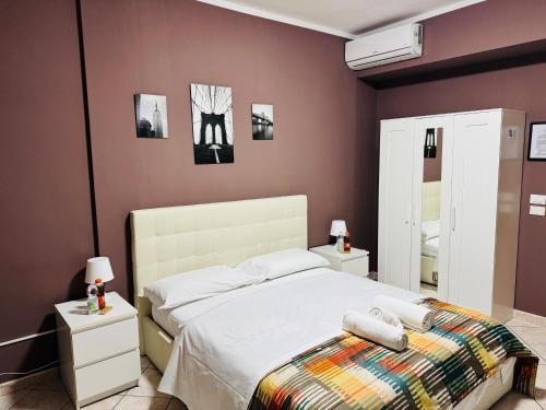 a bedroom with a white bed and purple walls at Nirvana House Pisa in Pisa