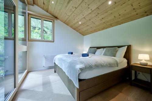 a bedroom with a large bed with a wooden ceiling at Chalet Mountain Love, spectacular views, spacious & luxurious in Lauterbrunnen