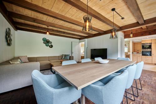 a dining room with a wooden table and blue chairs at Chalet Mountain Love, spectacular views, spacious & luxurious in Lauterbrunnen