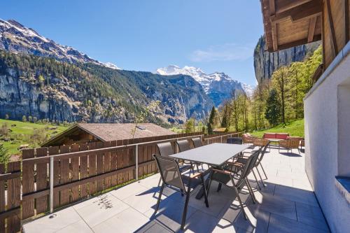 a balcony with a table and chairs and mountains at Chalet Mountain Love, spectacular views, spacious & luxurious in Lauterbrunnen